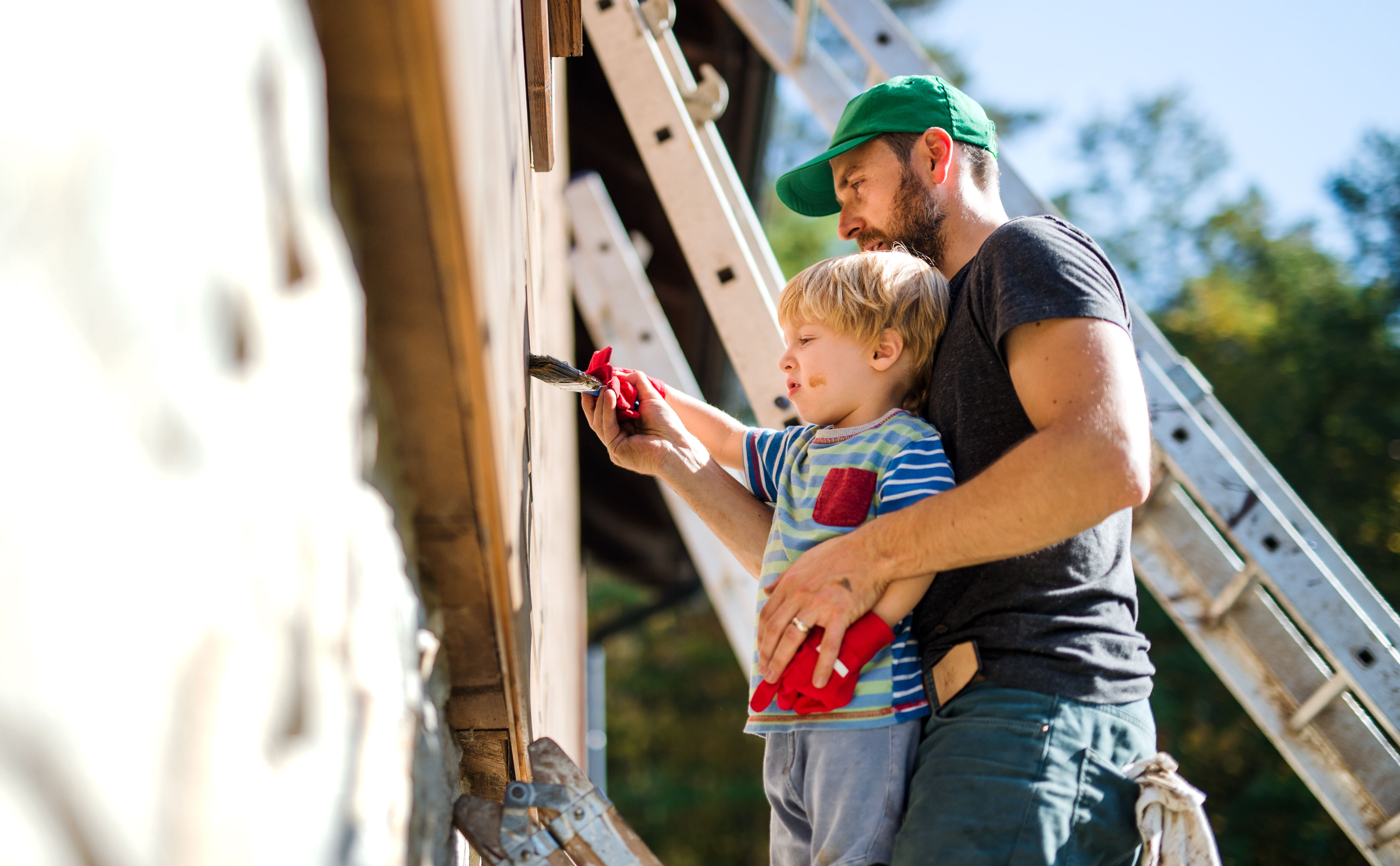 father and toddler paint their rental house property to get it ready to sell