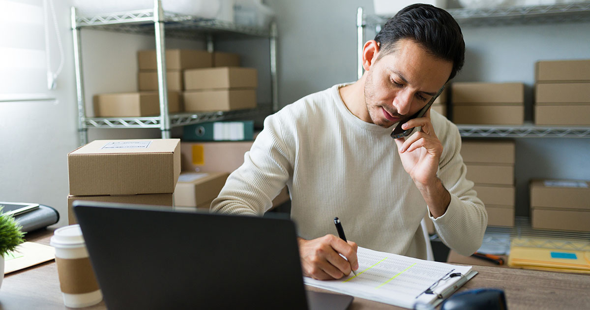 Latin entrepreneur taking notes while talking on the phone