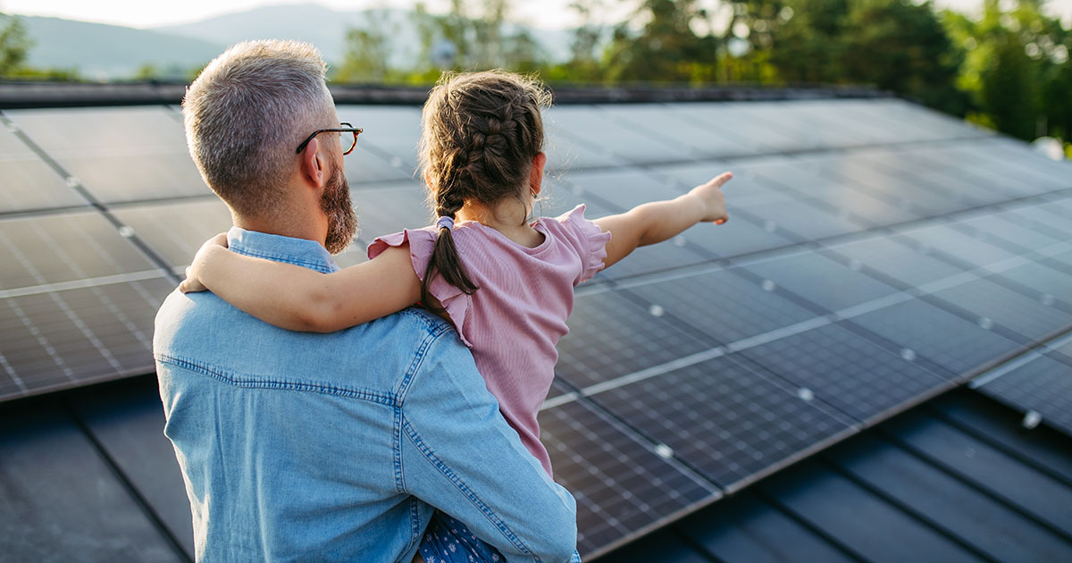 Father and daughter with newly installed solar panels on their home