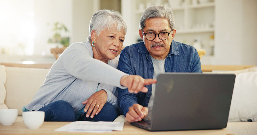 Senior, couple and planning on laptop in living room with document for taxes